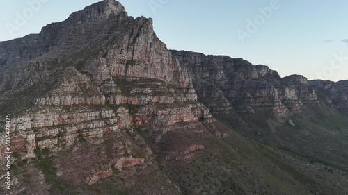 Sunset aerial shot of Table Mountain, Cape Town, South Africa, highlighting rugged cliffs, golden light