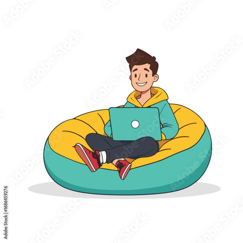 Young man happily using laptop on a comfortable bean bag chair while studying or working remotely