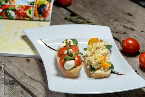 Bruschetta with tomatoes and kami spreads in a white plate on a wooden background
