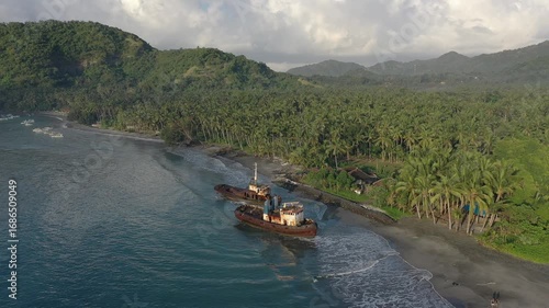 Wallpaper Mural Two large rusty abandoned ships standing in turquoise ocean water close to the shore, with hills and jungle-covered mountains in the background Torontodigital.ca