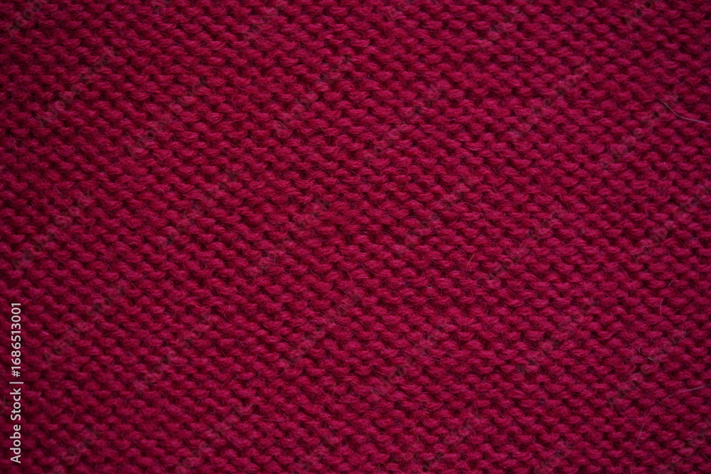 Fototapeta premium red Wool texture – red knitted fabric close-up Close-up texture of burgundy knitted wool fabric. Detailed symmetrical knit pattern. Soft textile background, suitable for fashion, crafts