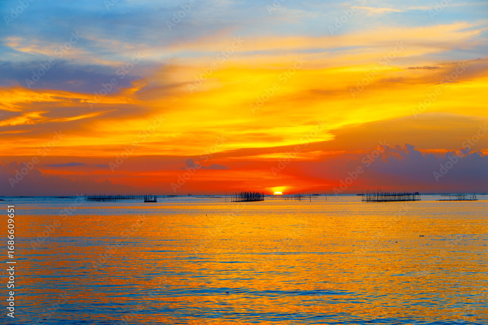 Obraz premium sunset in the sea. Beautiful colorful sky and cloud in twilight time background. Orange fluffy clouds and sun sunlight reflection in the blue sky.