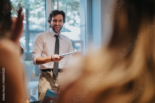 Photos A professional presenter engages a group in an interactive business workshop in a bright, well-lit room