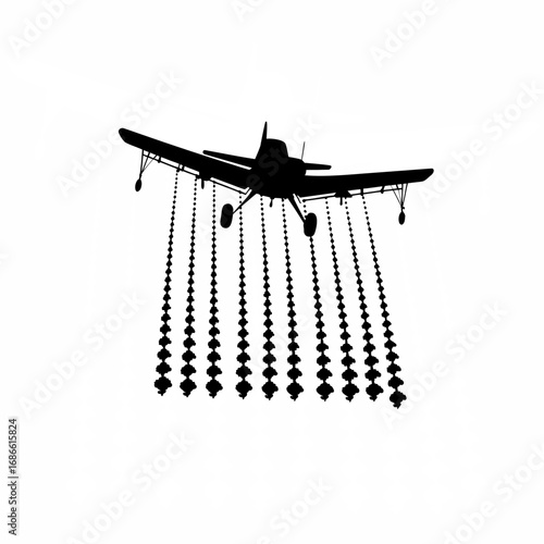 Silhouette of crop duster spraying fertilizer over agricultural fields
