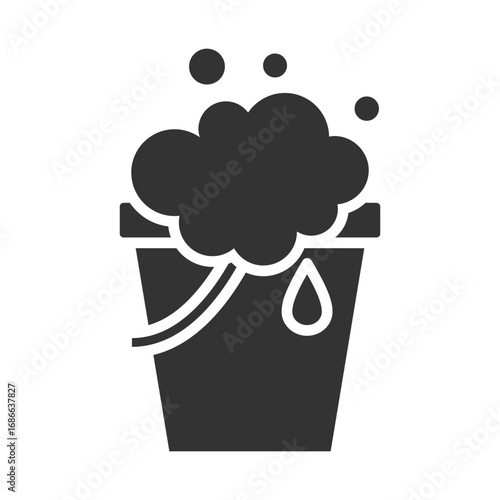A dark gray bucket with suds overflowing and a water drop on the side Bubbles float above. Editable stroke. Icon vector illustration