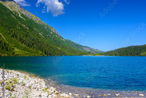 landscape with alpine lake in summer. beautiful view near rysy peaks in poland. travel background of high tatras with blue sky and clouds