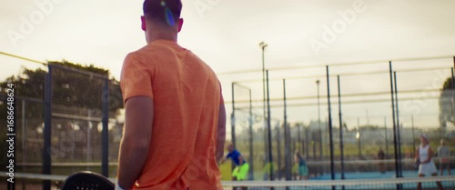 People enjoying an energetic game of padel on a bright outdoor court
