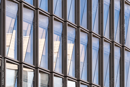 Wallpaper Mural Contemporary glass facade with repeating vertical lines, reflecting city environment and daylight, architectural detail symbolizing modern design, corporate presence and structural innovation Torontodigital.ca