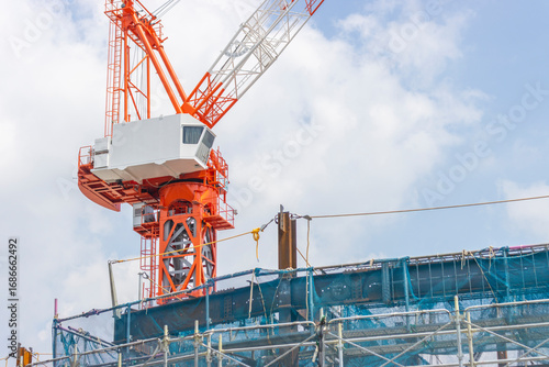 クライミングクレーンと建設中のビル。建設現場のイメージ