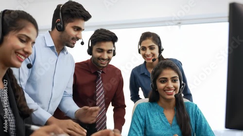 Group of diverse call center workers looking at computer and pointing. Customer service team in office, people with headset, teamwork and technology concept.