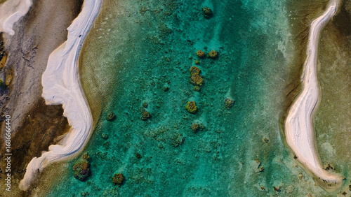Aerial view of turquoise waters embracing the soft, sandy shores of a tropical paradise, creating a mesmerizing contrast of colors and textures, French Polynesia.