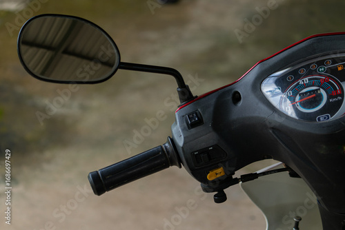 Close-up detail of the handlebar, mirror, and speedometer of a scooter in Vietnam. A common vehicle in Asia.