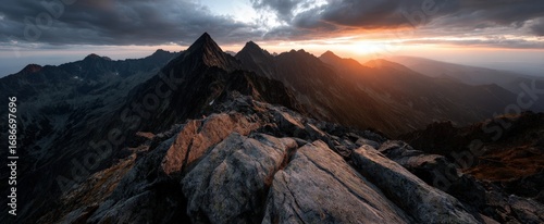 A rocky mountain with a cloudy sky in the background