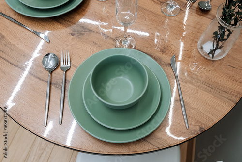 An Elegant Green Dinner Set on a rustic Wooden Table, showcasing a stylish Dining Arrangement ideal for gatherings or special occasions, complete with exquisite glassware