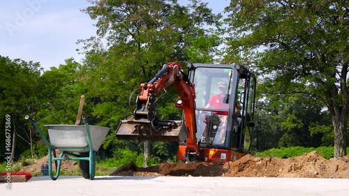 Mini excavator working at suburban construction site