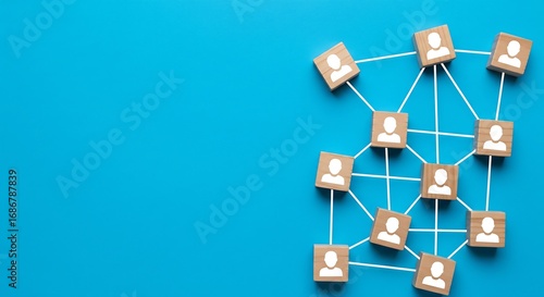 Wallpaper Mural Small wooden blocks with person icons, interconnected by thin white strings, forming a network on a vibrant blue background. Torontodigital.ca