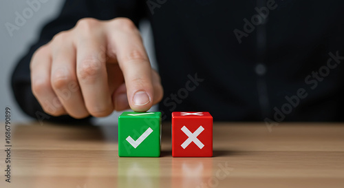 Decision making concept. Close up of a person's hand choosing between a green checkmark and a red cross symbol on a wooden table