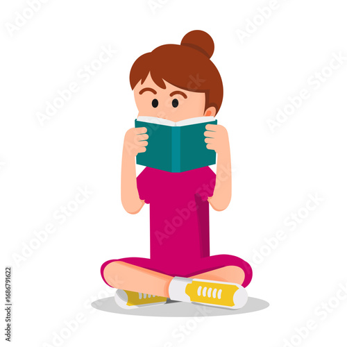 A little girl peeks out from behind the book she's reading