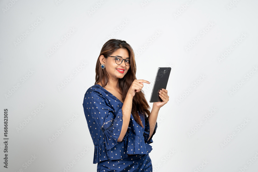 Naklejka premium Image of young woman, company worker in glasses, smiling and holding digital tablet, standing over white background