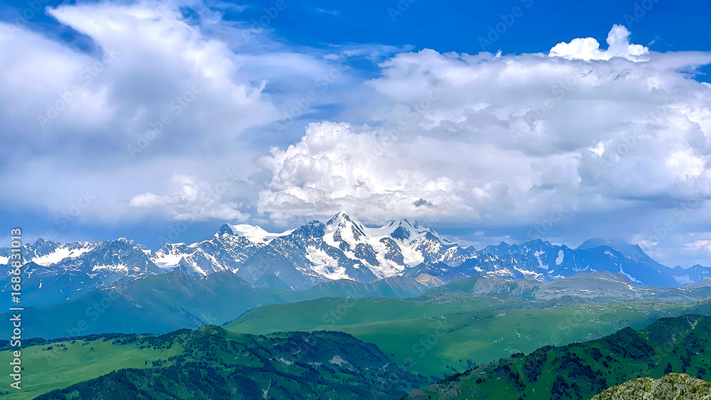 Obraz premium A trip to the Majestic Belukha Mountain Whale from Kazakhstan. Amazing landscape of snow-capped mountains and green hills. A trip to Russia