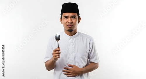 Young Asian Man with Stomach Ache Holding Spoon
