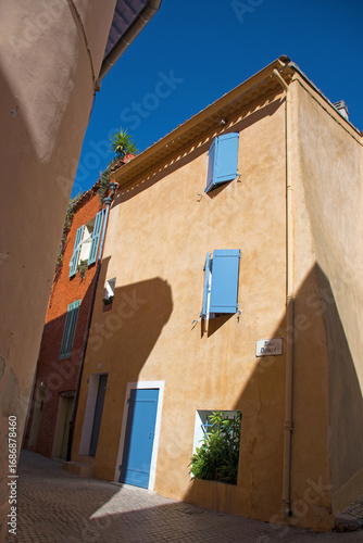 Le Castellet, Frankreich. Typische, enge Gasse in Pastelltönen mit blauem Himmel