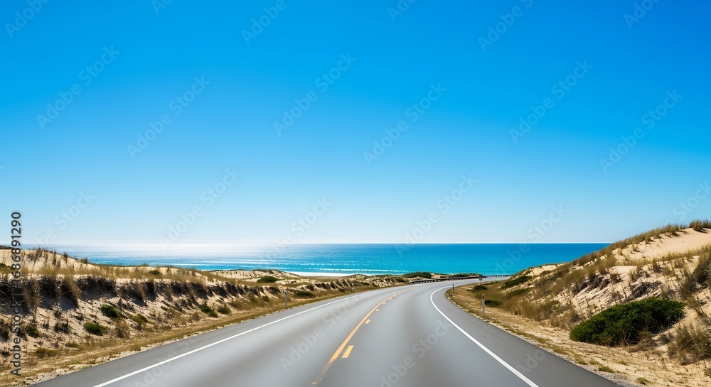 Coastal Highway Winding Through Sandy Dunes Under a Vivid Blue Sky Coastal Highway Winding Through Sandy Dunes Under a Vivid Blue Sky