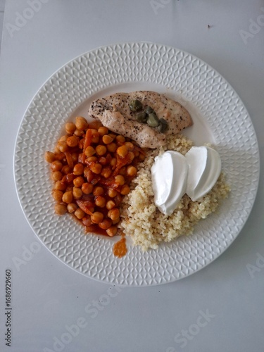 Healthy lunch meal. Chickpea. Chicken fillet, bulgur and yogurt on the plate.