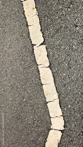 Wallpaper Mural Close-up view of a cracked white road marking on asphalt Torontodigital.ca