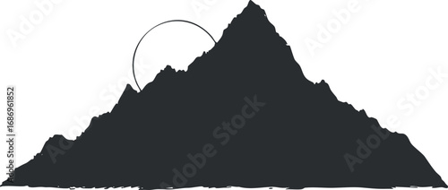 Silhouette of a mountain peak with the sun partially visible behind it in a natural landscape.