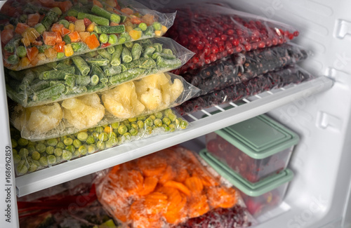 Φωτογραφία Plastic bags with different frozen vegetables and berries in refrigerator
