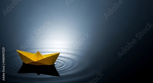 Yellow paper boat floating on dark water, creating ripples in the calm surface