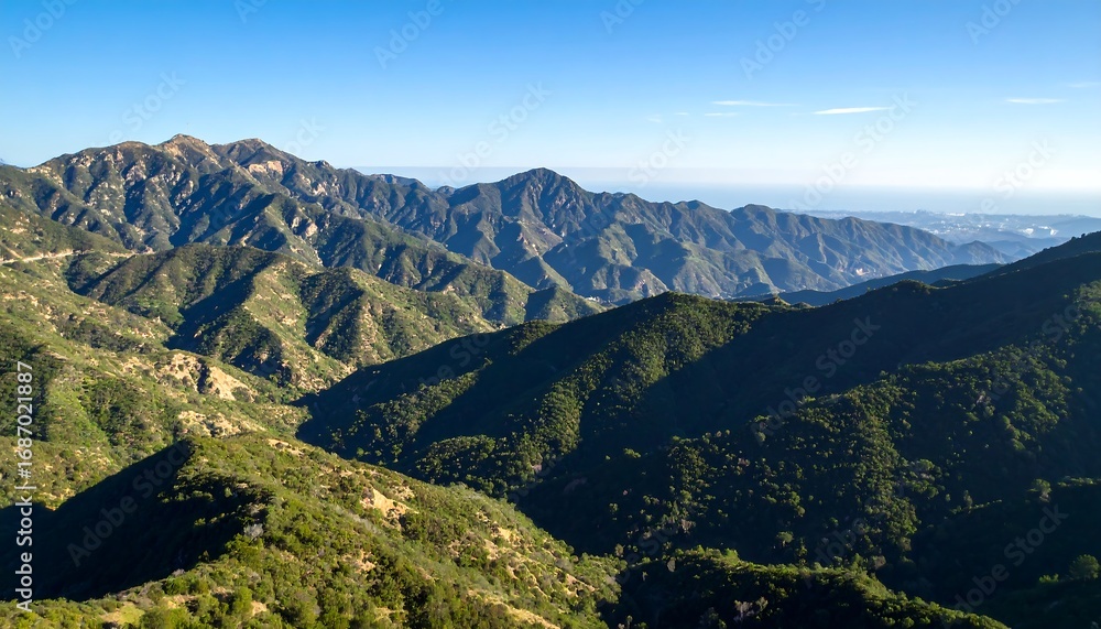 Fototapeta premium Mountain vista, lush green slopes, clear blue sky