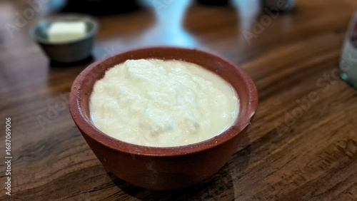 A small mud pot holds creamy curd, showcasing traditional charm and rustic simplicity in every wholesome serving