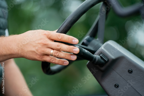 Wallpaper Mural Close-up of operator hand gripping black steering wheel of heavy machinery, symbolizing control, precision, and manual operation in construction equipment, agriculture, or industrial vehicles Torontodigital.ca