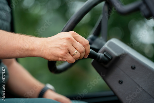 Wallpaper Mural Worker’s hand with wedding ring holding steering wheel inside industrial vehicle, representing driving, responsibility, labor, transportation, and connection between human and machine power Torontodigital.ca