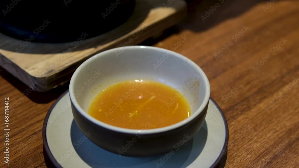 Soup pouring bowl person pouring orange soup into a bowl from a large pot outside at a rustic forest wedding reception Soup pouring bowl person pouring orange soup into a bowl from a large pot outside at a rustic forest wedding reception