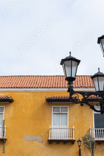 Wallpaper Mural Colonial architecture and street lamps illuminating a vibrant yellow building Torontodigital.ca