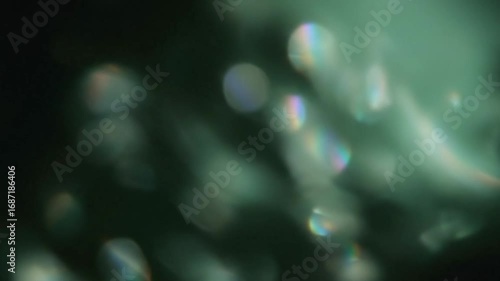 Beautiful, shimmering crystal light leaks and rainbow bokeh effects float and drift in a dark space. This magical and ethereal animation is perfect for creating a dreamy and atmospheric overlay