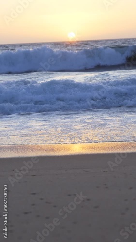 sea waves on the setting sun, which is reflected on the water and sand