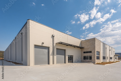 Modern warehouse building exterior view sunny day large doors loading dock