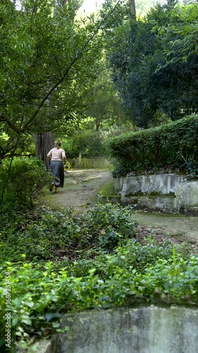 A girl runs in the woods in a long