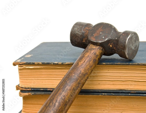 Antique hammer resting on aged books