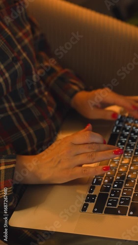 women's hands with red nails print in a warm dim light
