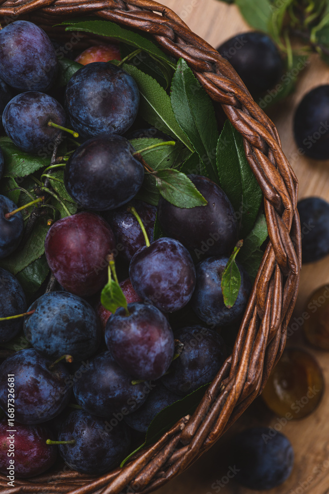 Fototapeta premium Ripe blue plums in a basket