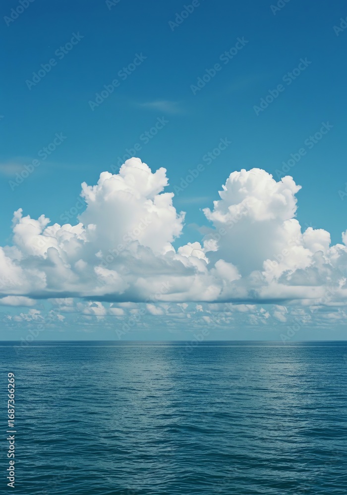 Fototapeta premium Serene ocean view featuring cumulus clouds under a clear blue sky