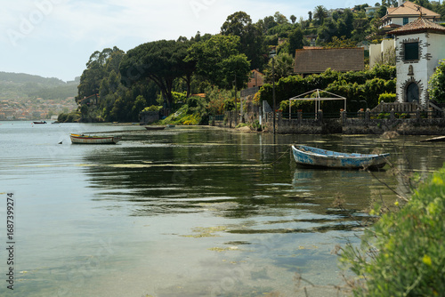 A couple of boats are moored in the Galician estuaries, in a very small village. The boats are old and faded, but the scene is beautiful.