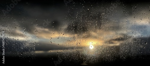 Rain-streaked window view of a dramatic sunset