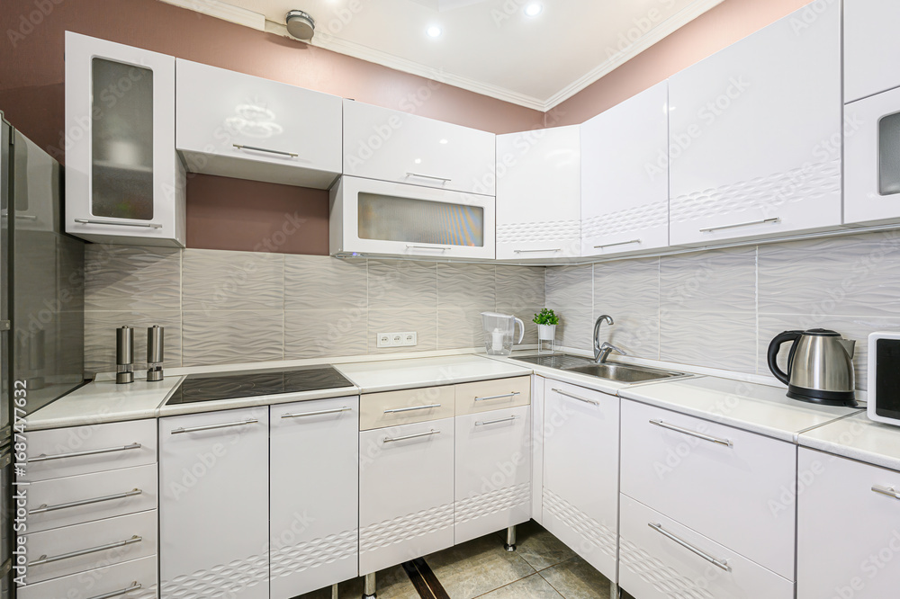 Fototapeta premium modern kitchen with white cabinets, stainless steel appliances, and textured backsplash. The design is clean and functional