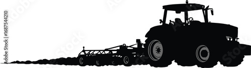 farm tractor working field with plow attached behind